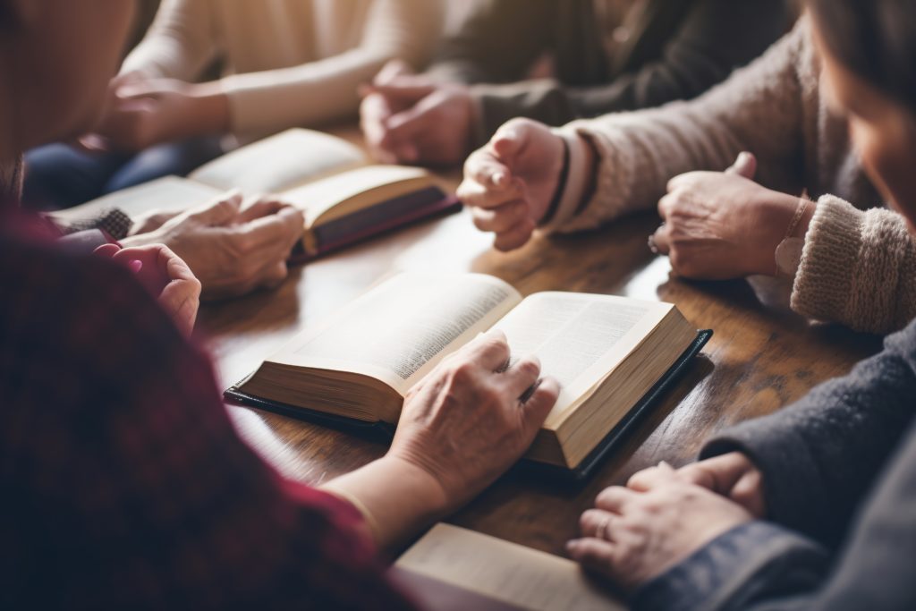 Multiethnic group of people praying and reading the Bible together